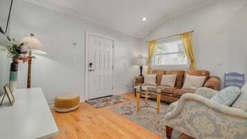 A living room with a white door, a sofa, a coffee table, and a lamp.