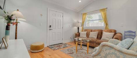 A living room with a white door, a sofa, a coffee table, and a lamp.