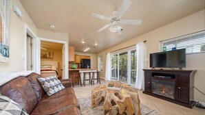 A living room with a leather couch, a coffee table, a fireplace, and a television.