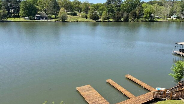 Un lac paisible avec une jetée en bois qui s’avance sur l’eau.