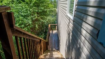 A wooden deck leading to a house with siding.