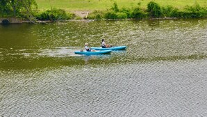 Une rivière paisible où flottent deux personnes dans un canoë bleu.