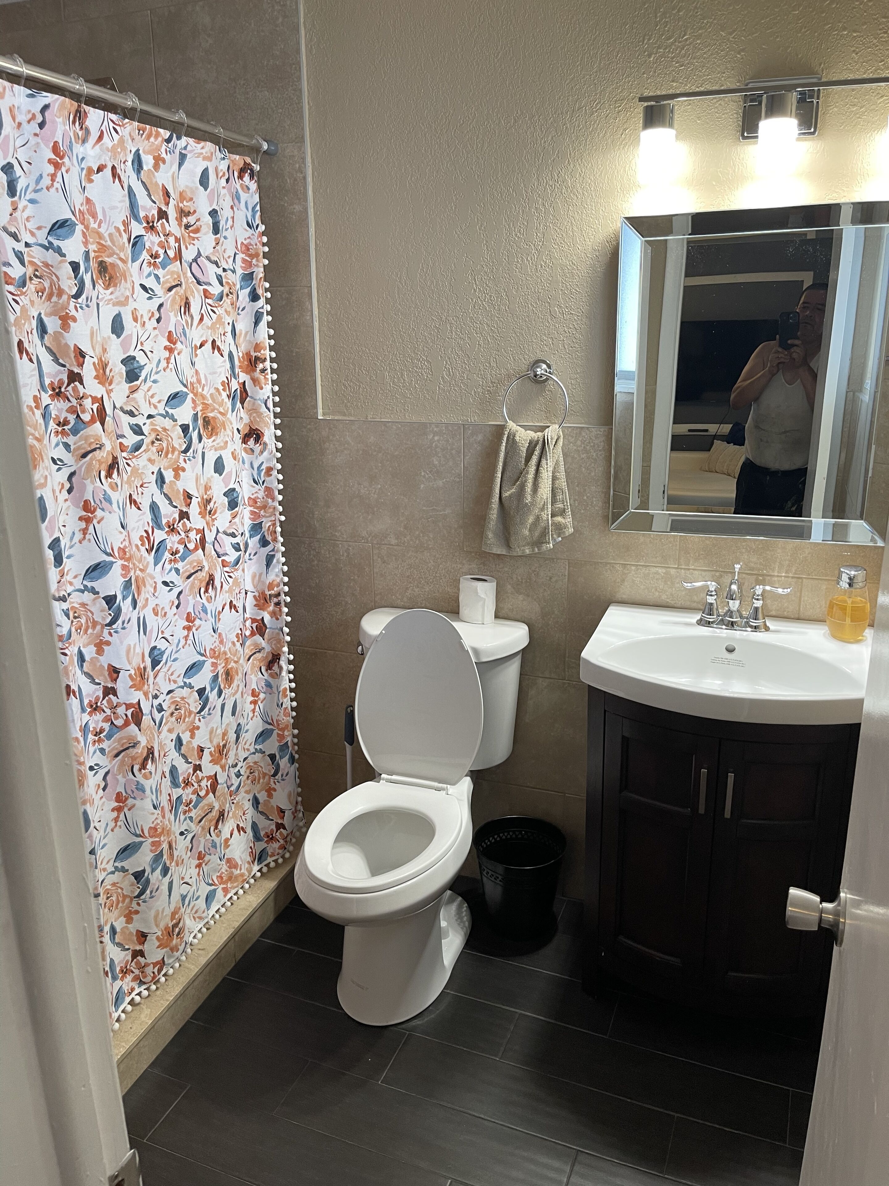 Un baño con inodoro, lavamanos y cortina de ducha.