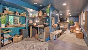 A cozy room with a blue accent wall, a fireplace, and a comfortable seating area. - Tranquil mountainhouse w/hot tub, super close to trails & wineries- pet friendly (Linden)