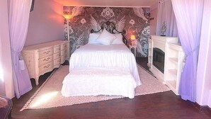 A bedroom with a large bed, a nightstand, a dresser, and a fireplace. - Cozy Casita, overlooking Senoran Desert Peserve, Cave Creek (Phoenix)