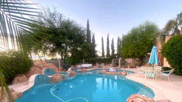 A swimming pool with rock formations and lounge chairs. - Cozy Casita, overlooking Senoran Desert Peserve, Cave Creek (Phoenix)