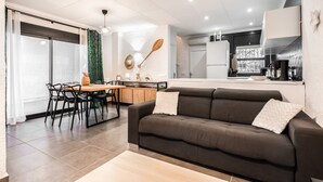 A modern kitchen with a dining area, a sofa, and a large window. - WELCS VILLA 022 EMP La Morgana con piscina priva (Empuriabrava)