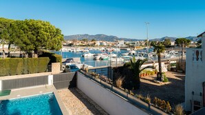 Un porto turistico con barche, una piscina e vista sulle montagne.
