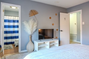Cozy retreat with a large bed, flat-screen TV, and convenient door access.