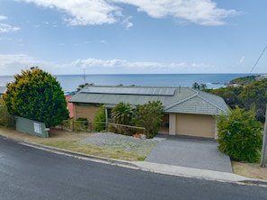 A residential house with a sloped roof, solar panels, and a view of the ocean. - Becker Bliss - 5 bedrooms, ocean views, sleeps 16 (Forster)