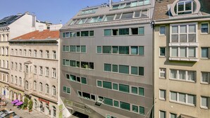 Un edificio de varios pisos con fachada moderna, ventanas amplias y techo plano con tragaluces.