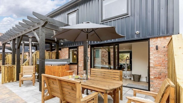An outdoor patio with wooden furniture and a pergola. - Fully Accessible-Disabled Adapted-Hot Tub-Pets (Coughton)