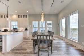 Enjoy meals in the well-lit kitchen and dining area with a central island and large wooden table.