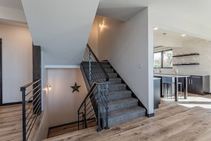 A modern interior with a staircase, wooden flooring, and a kitchen area. - Monthly Stays Available! Dog Friendly-Great Views (Steamboat Springs)