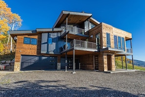 A modern multi-story house with a garage, wooden exterior, and a balcony. - Monthly Stays Available! Dog Friendly-Great Views (Steamboat Springs)
