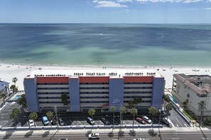 A hotel with a red roof, multiple floors, and a view of the beach and ocean. - Relax Beachfront with Stunning Beach Views. Heated Swimming Pool.  Tickets to Top Attractions. (Madeira Beach)