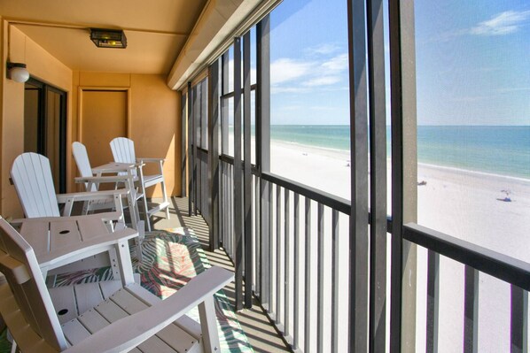 A balcony with white chairs and a view of a beach. - Relax Beachfront with Stunning Beach Views. Heated Swimming Pool.  Tickets to Top Attractions. (Madeira Beach)