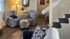 Amplia sala de estar con techo alto, una escalera y vistas del piso superior.