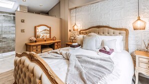 Une chambre à coucher avec un grand lit, une coiffeuse avec un miroir et une commode.