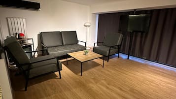 Tremannsrom – deluxe | Oppholdsområde | En 42-tommers smart-TV med Parabol-TV samt TV