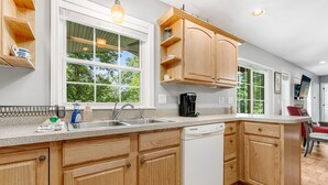 Una cocina moderna con armarios de madera, lavavajillas y cafetera.