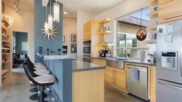 Una cocina moderna con barra, electrodomésticos de acero inoxidable y armarios de madera.
