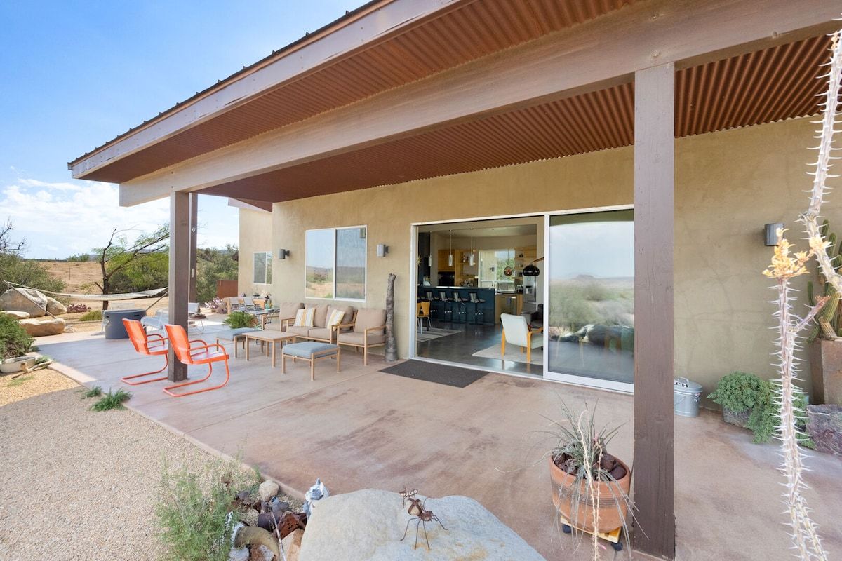 Un espace extérieur aménagé avec une terrasse, un coin repas et une vue sur l’intérieur.