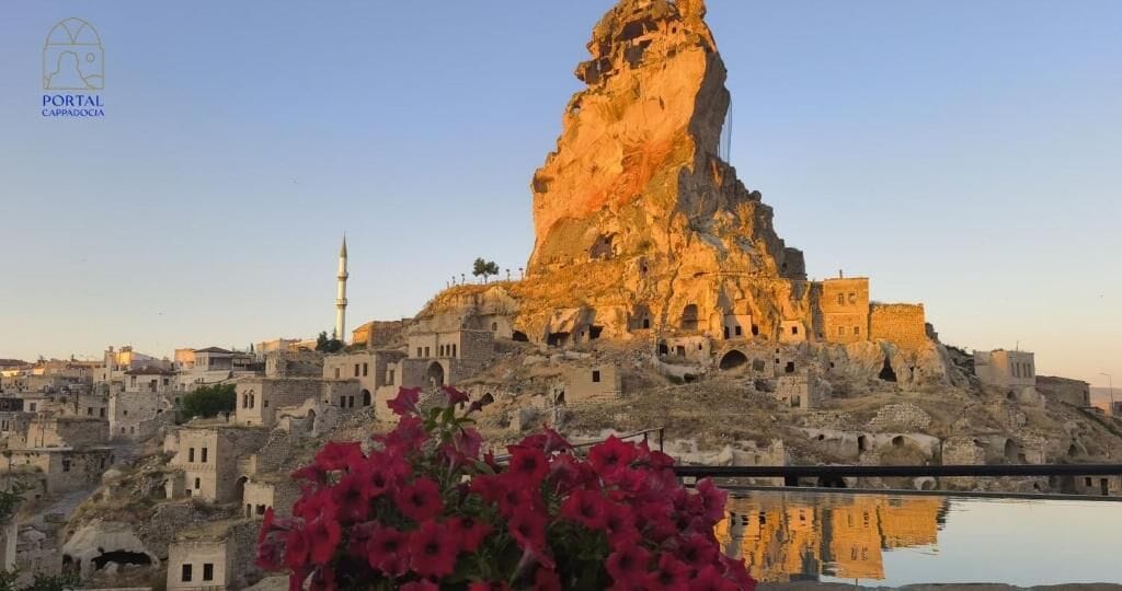 Un paisaje urbano histórico con una destacada formación rocosa y una mezquita con minarete.