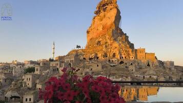Un paisaje urbano histórico con una destacada formación rocosa y una mezquita con minarete.