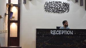 A reception desk with a marble top and a sign that reads "RECEPTION". - Comfort Inn Hotel Peshawar (Mekhtar)