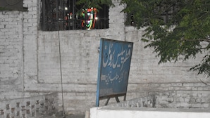 A brick wall with a blue signboard. - Comfort Inn Hotel Peshawar (Mekhtar)