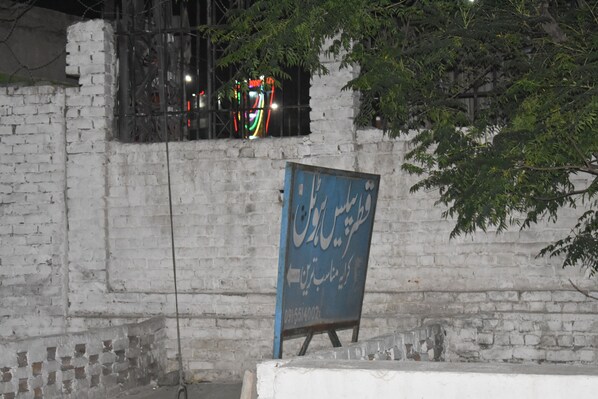 A brick wall with a blue signboard. - Comfort Inn Hotel Peshawar (Mekhtar)