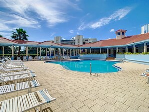 Un área de piscina con sillas de descanso y una pileta.