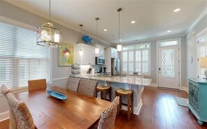 Enjoy casual meals at the central island or dining table, surrounded by comfortable wicker chairs.