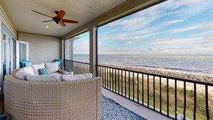 A covered outdoor seating area with a view of the beach.