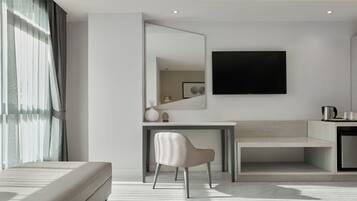 Una habitación de hotel moderna con una cama, un escritorio, una silla, un televisor de pantalla plana y un espejo grande.
