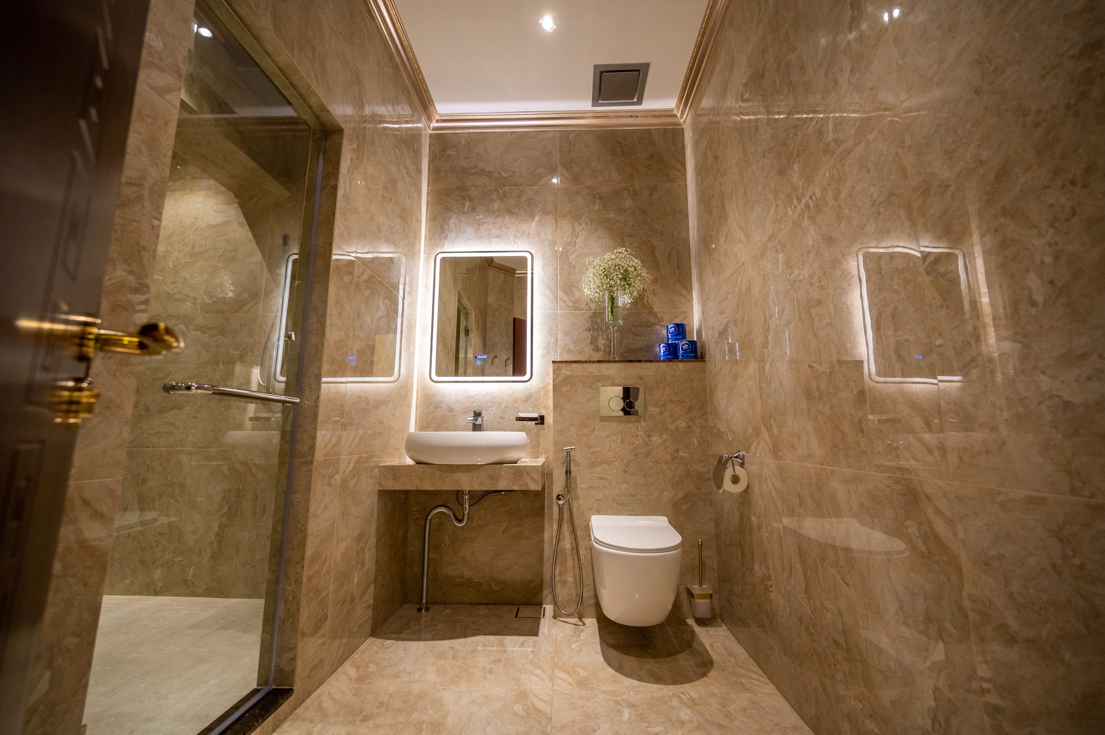 A modern bathroom with a glass-enclosed shower, a sink with a mirror, and a toilet.