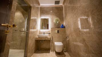 A modern bathroom with a glass-enclosed shower, a sink with a mirror, and a toilet.
