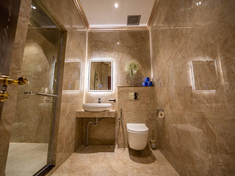 A modern bathroom with a glass-enclosed shower, a sink with a mirror, and a toilet.