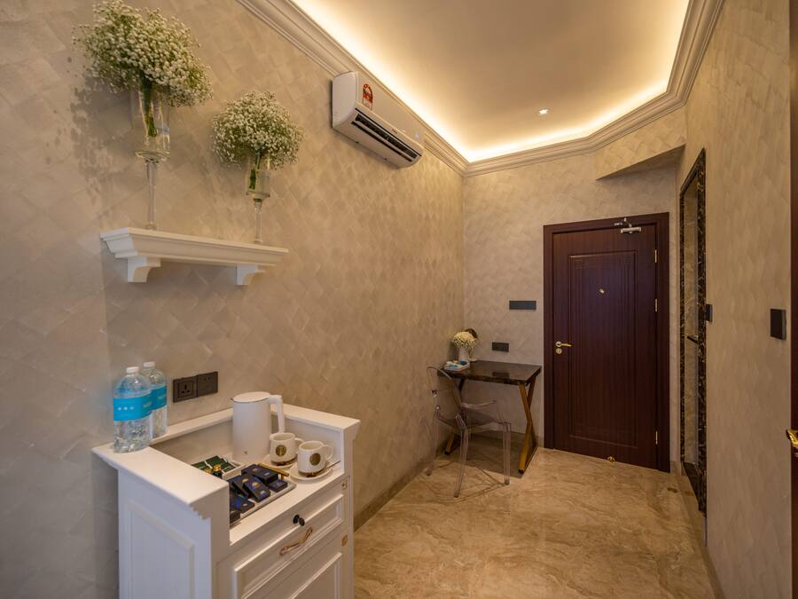 A hotel bathroom with a vanity, a mirror, a shower area, and a door.