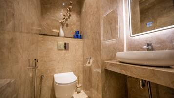 A modern bathroom with a toilet, bidet, and sink.