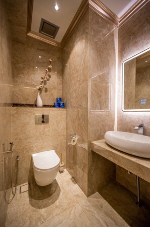 A modern bathroom with a marble floor, a white toilet, a sink, and a mirror. - ACJ Residence - A Member of The Luxury Stay Group (Kota Kinabalu)