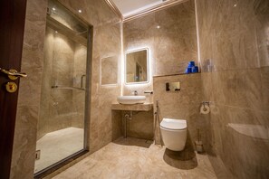 A modern bathroom with a glass-enclosed shower, a sink with a mirror, and a toilet. - ACJ Residence - A Member of The Luxury Stay Group (Kota Kinabalu)