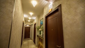 A hallway with marble walls, wooden doors, and chandeliers. - ACJ Residence - A Member of The Luxury Stay Group (Kota Kinabalu)