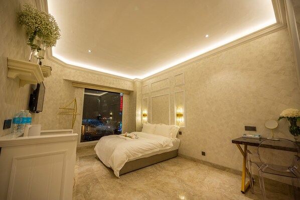 A modern bedroom with a bed, bedside table, and a window with a city view. - ACJ Residence - A Member of The Luxury Stay Group (Kota Kinabalu)