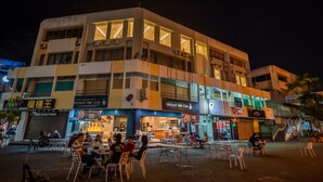 A multi-story building with various shops on the ground floor, including a restaurant and a café. - ACJ Residence - A Member of The Luxury Stay Group (Kota Kinabalu)