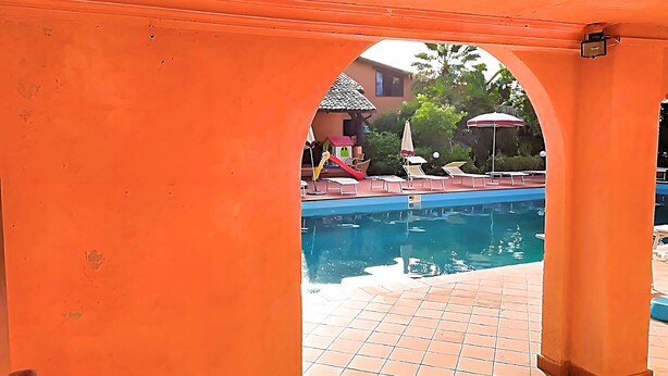 A swimming pool with a tiled deck and lounge chairs. - Belvilla by OYO SANT IRENE (Sant'Irene-torre Vecchia)