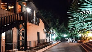 A building with a staircase, a balcony, and a well-lit outdoor area with chairs and tables. - Belvilla by OYO SANT IRENE (Sant'Irene-torre Vecchia)