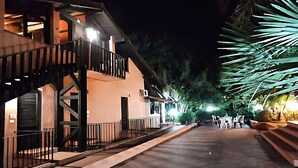 Un edificio con balcón, mobiliario exterior y una escalera.