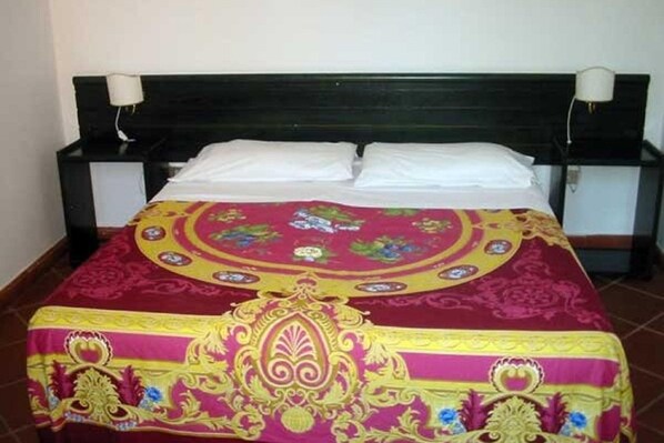 A bed with a patterned bedspread and two white pillows. - Belvilla by OYO Appealing apartment with pool (Sant'Irene-torre Vecchia)